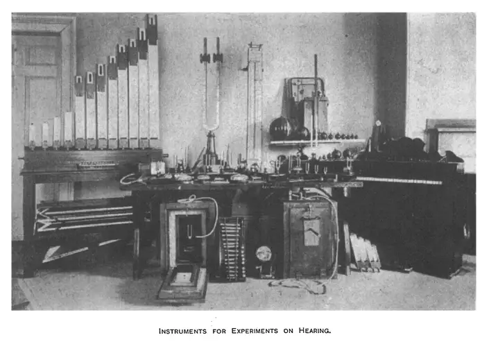 Archival photograph of a laboratory bench of acoustic apparatus — organ pipes, tuning forks and resonators.